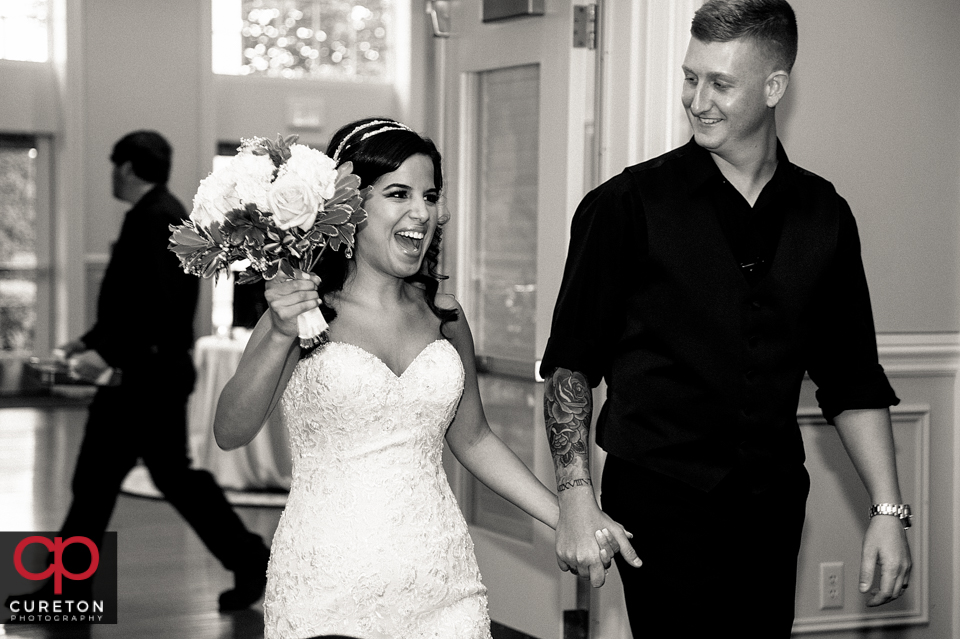 Bride and groom entering their wedding reception.