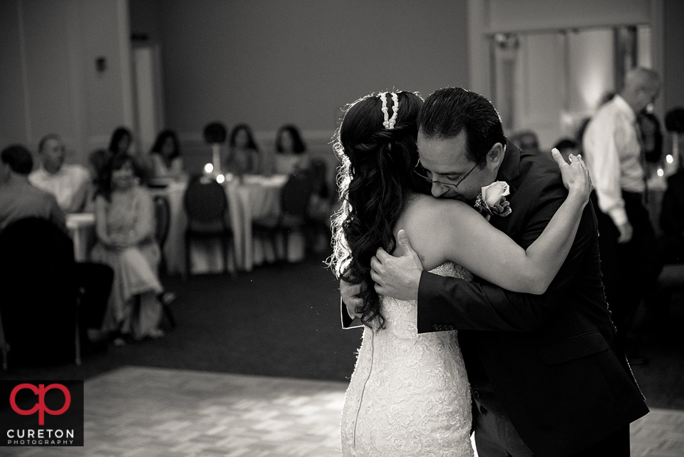 Bride her father hugging after they danced at her wedding reception.