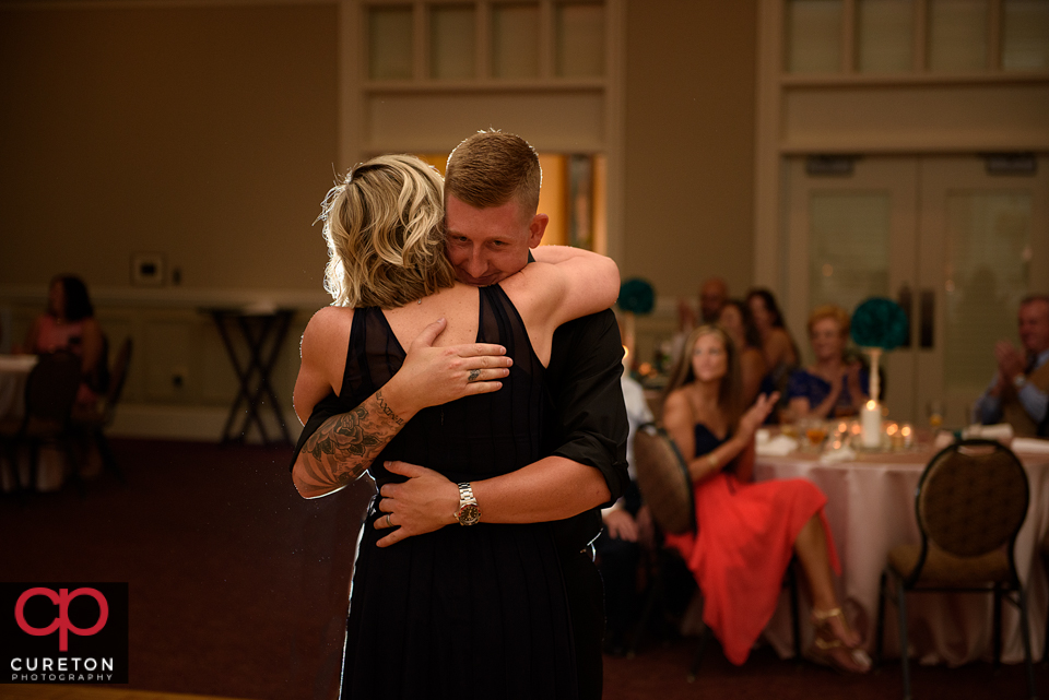 Groom hugging his mother at the wedding reception.