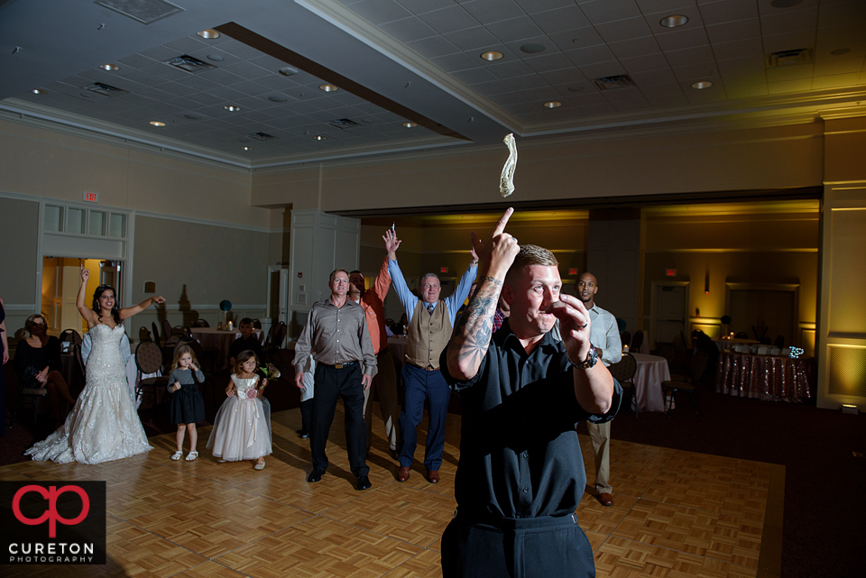 Groom throwing the garter.