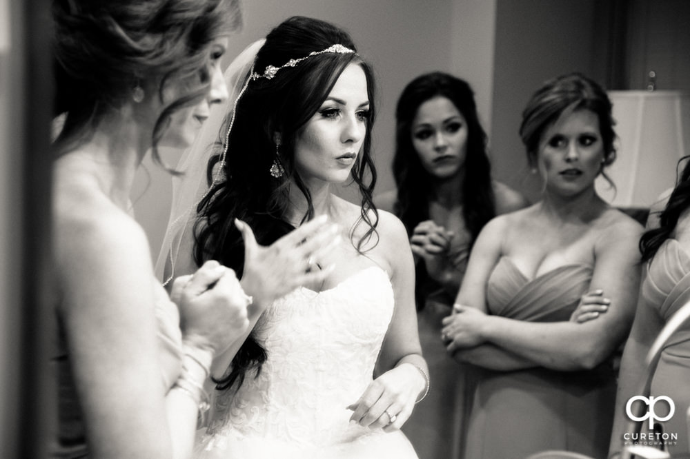 Groom looking in the mirror before her wedding.