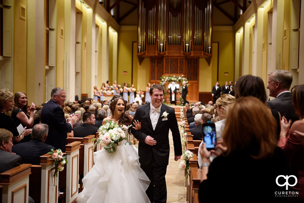 Bride and groom walkign down the aisle after their wedding at Daniel Chapel.