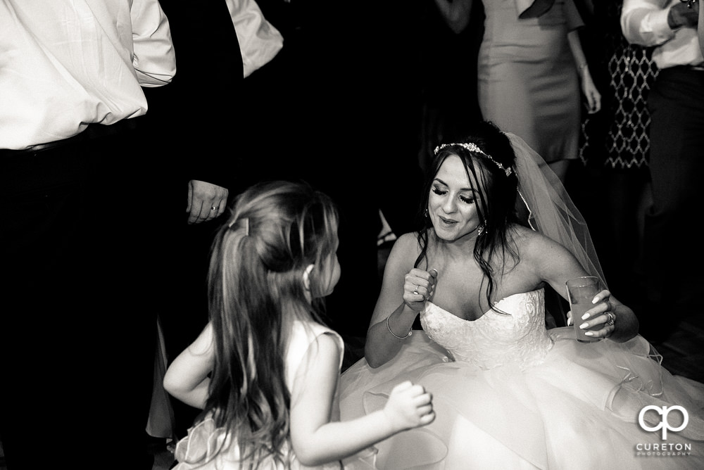 Bride and the flower girl dancing.