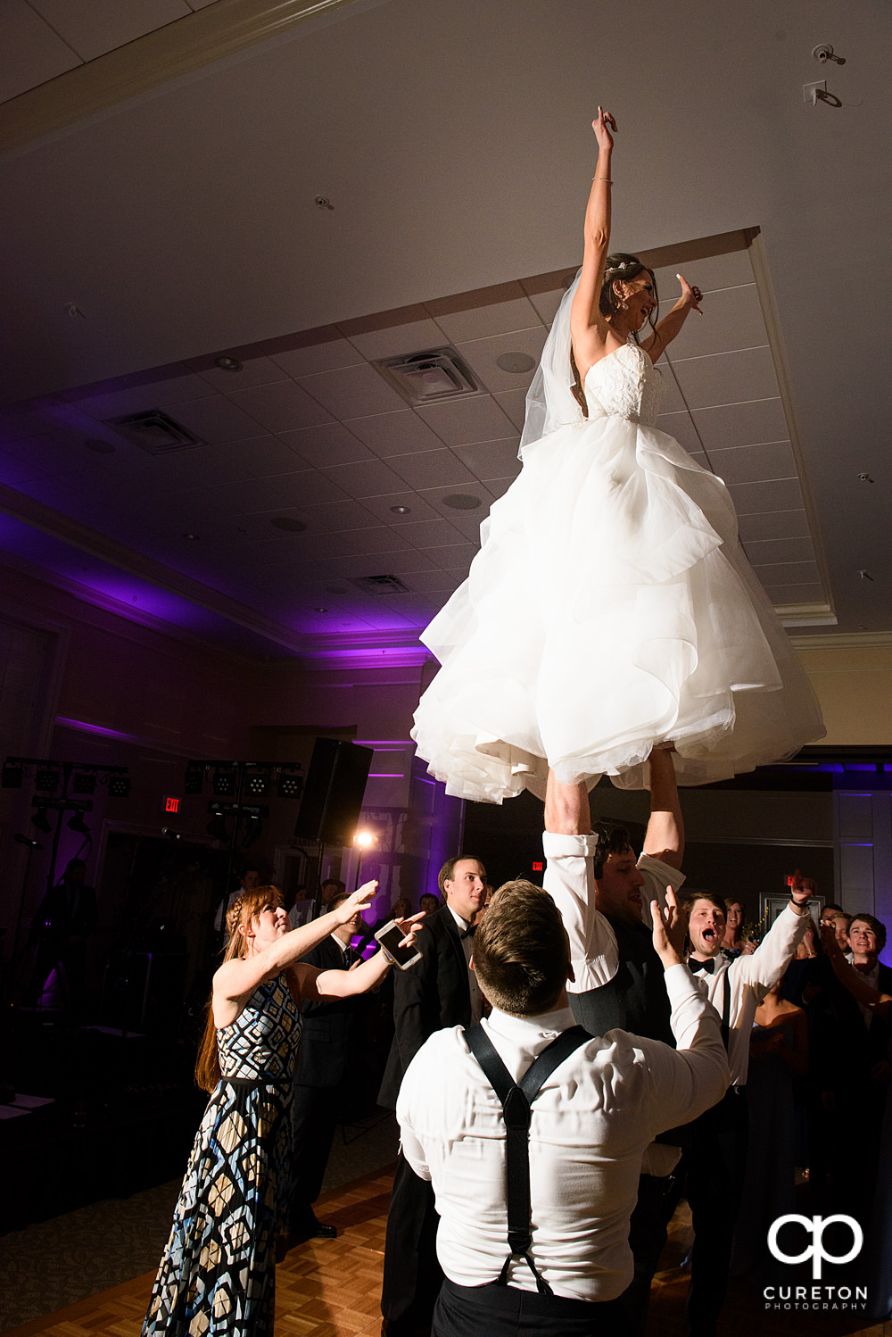Bride performing a cheer stunt at her wedding.