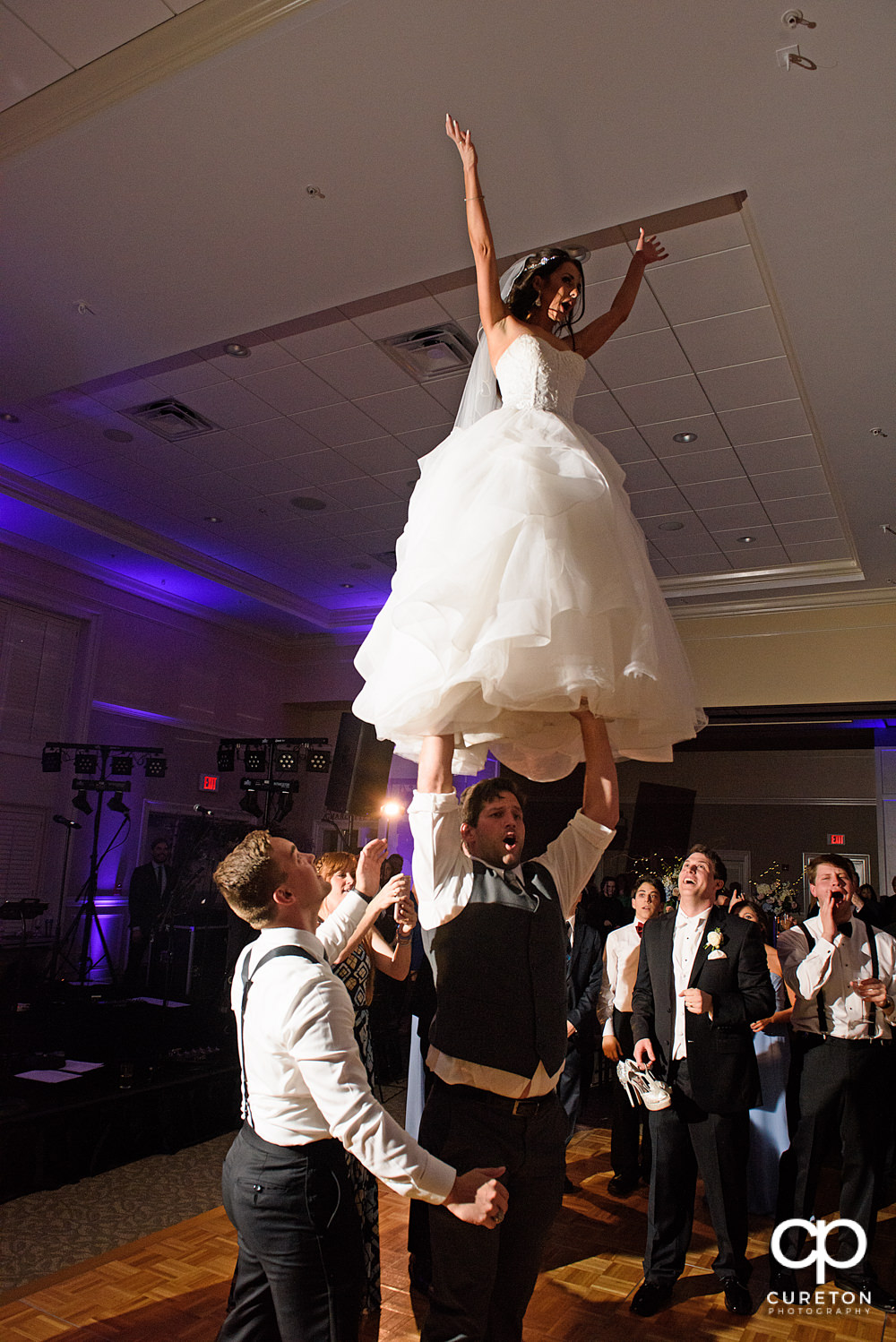 Bride performing a cheer stunt at her wedding.