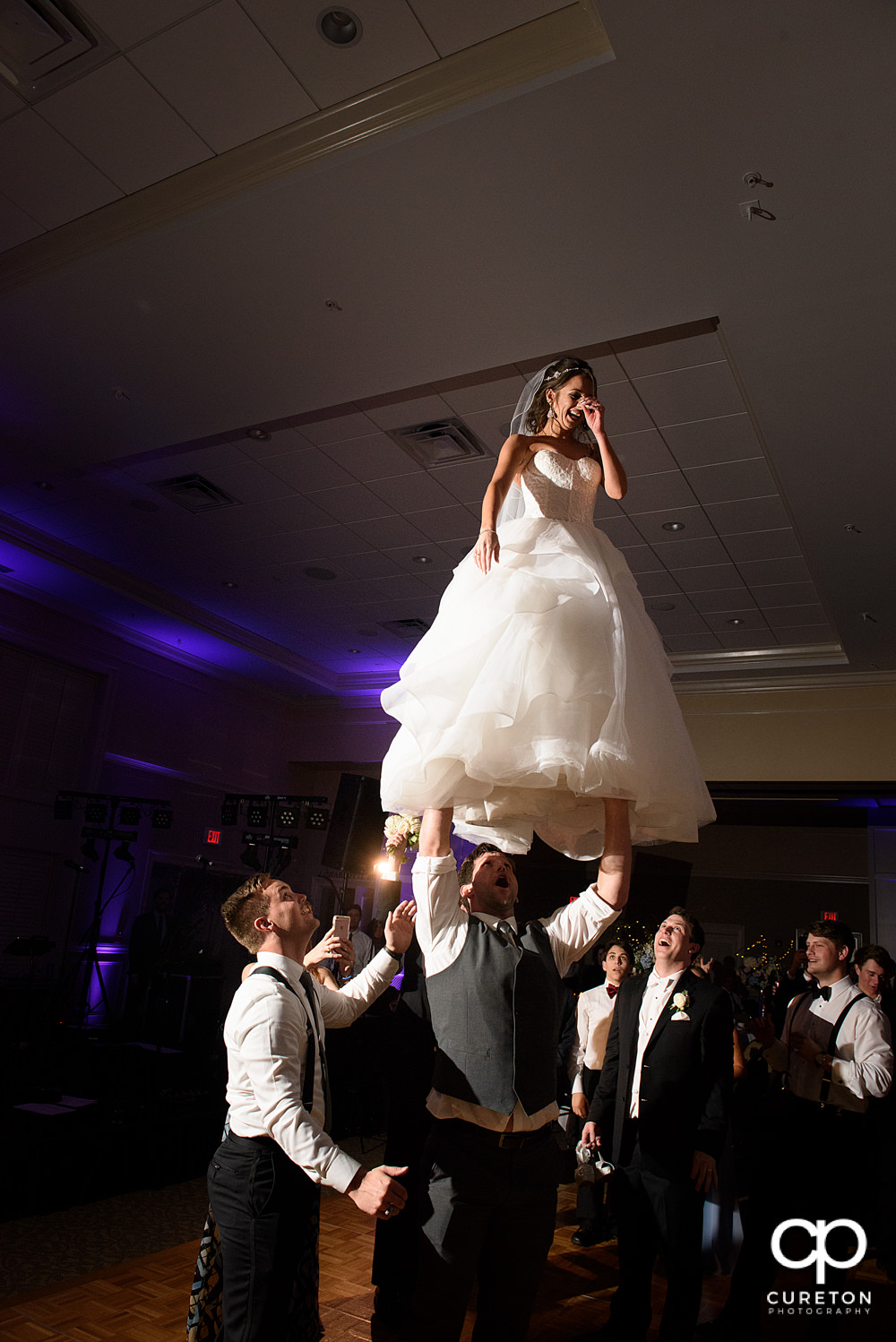 Bride performing a cheer stunt at her wedding.