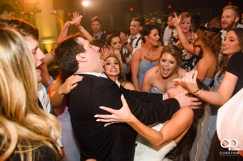 Groom kissing his bride on the dance floor.