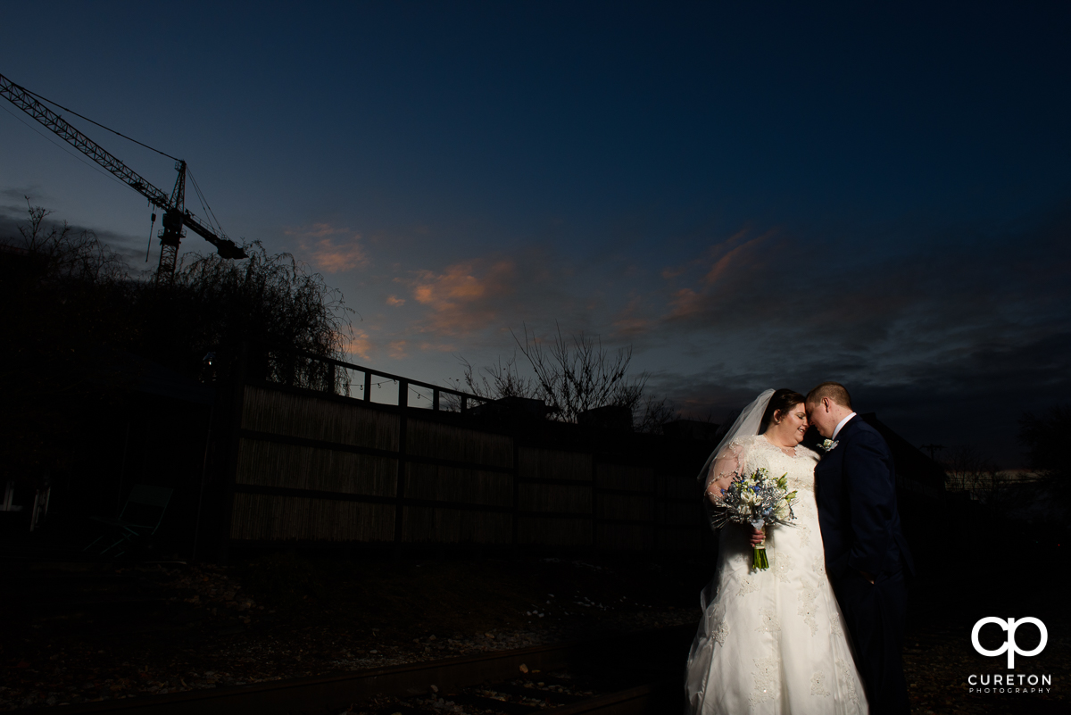 Bride and Groom cuddling after their December Old Cigar Warehouse wedding in Greenville,SC.