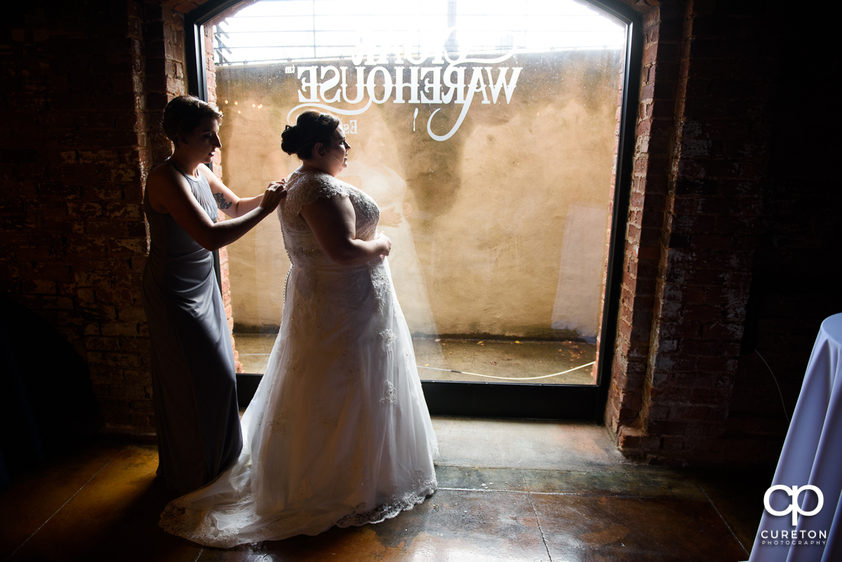Bride getting her dress on at Old Cigar Warehouse.