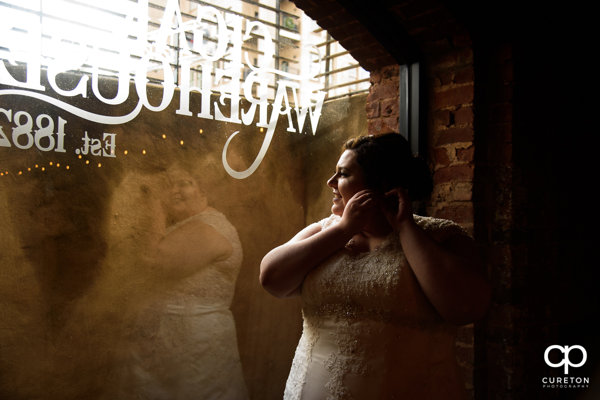 Bride putting her earrings on at The Old Cigar Warehouse before the wedding.