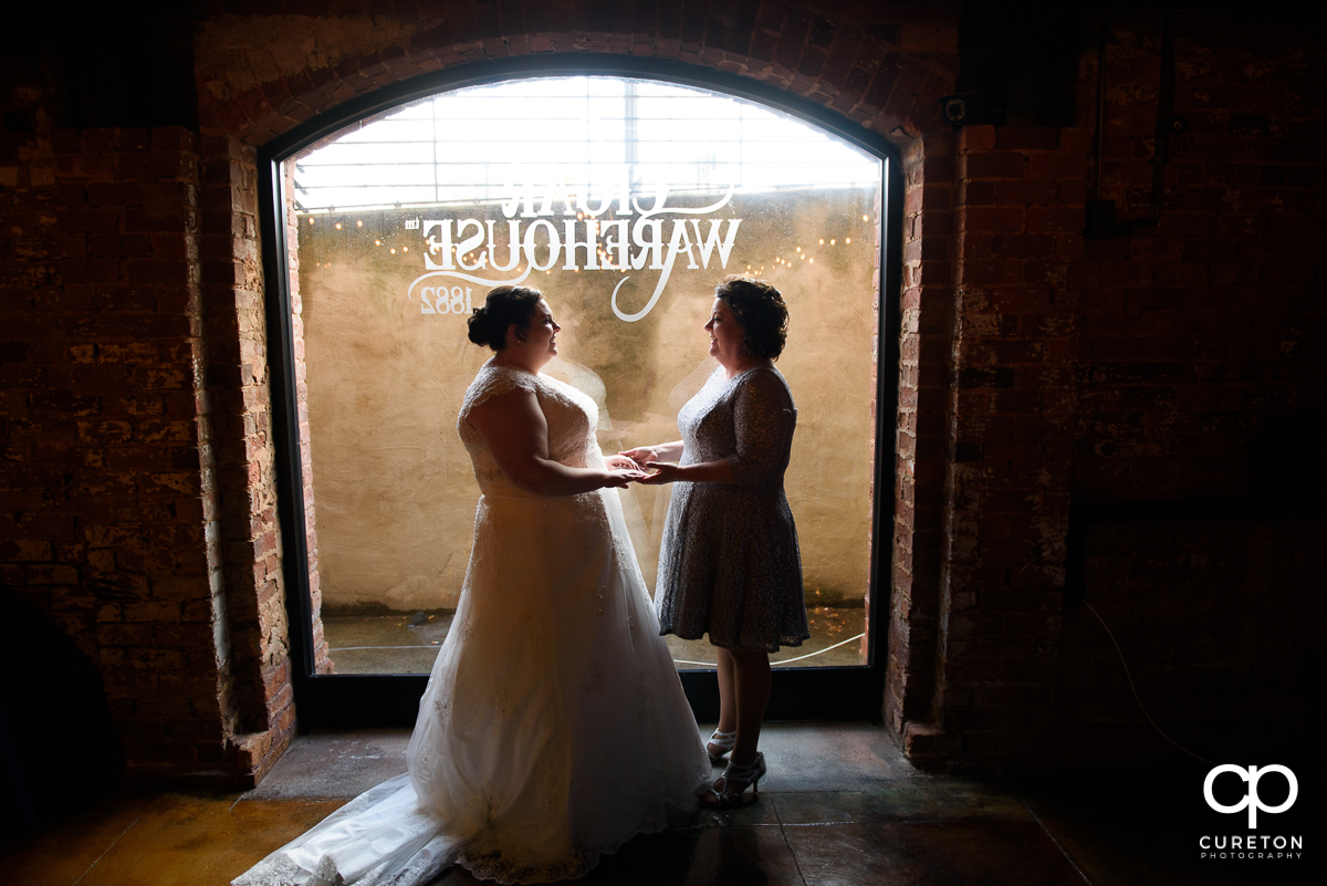Bride and her mother standing in the window of The Old Cigar Warehouse before the wedding.