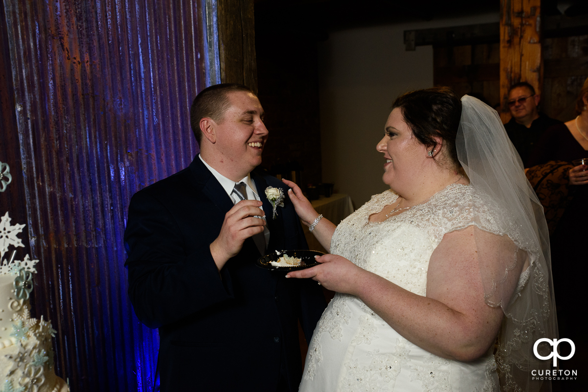 Bride and groom cutting the cake at The Old Cigar Warehouse.
