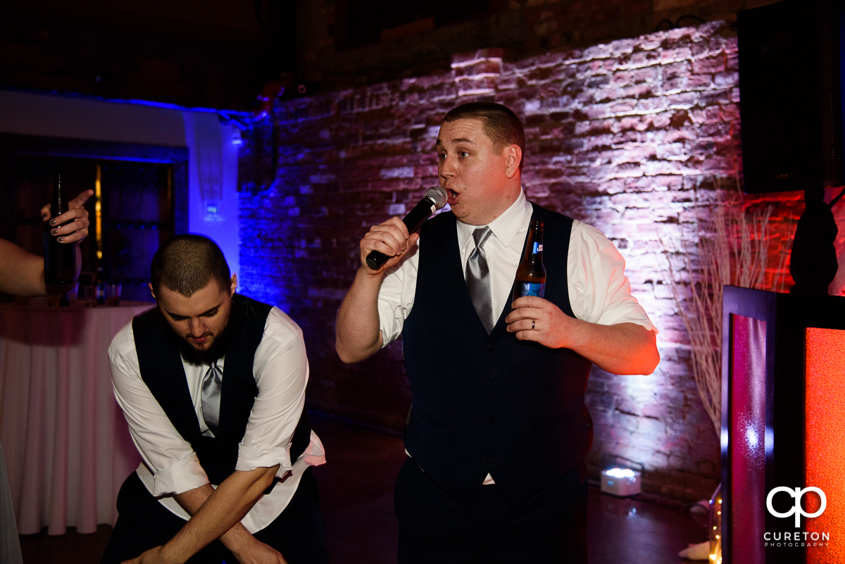 Groom with a microphone at the wedding reception.