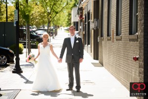 Bride and groom walking on main street in downtown Greenville,SC.