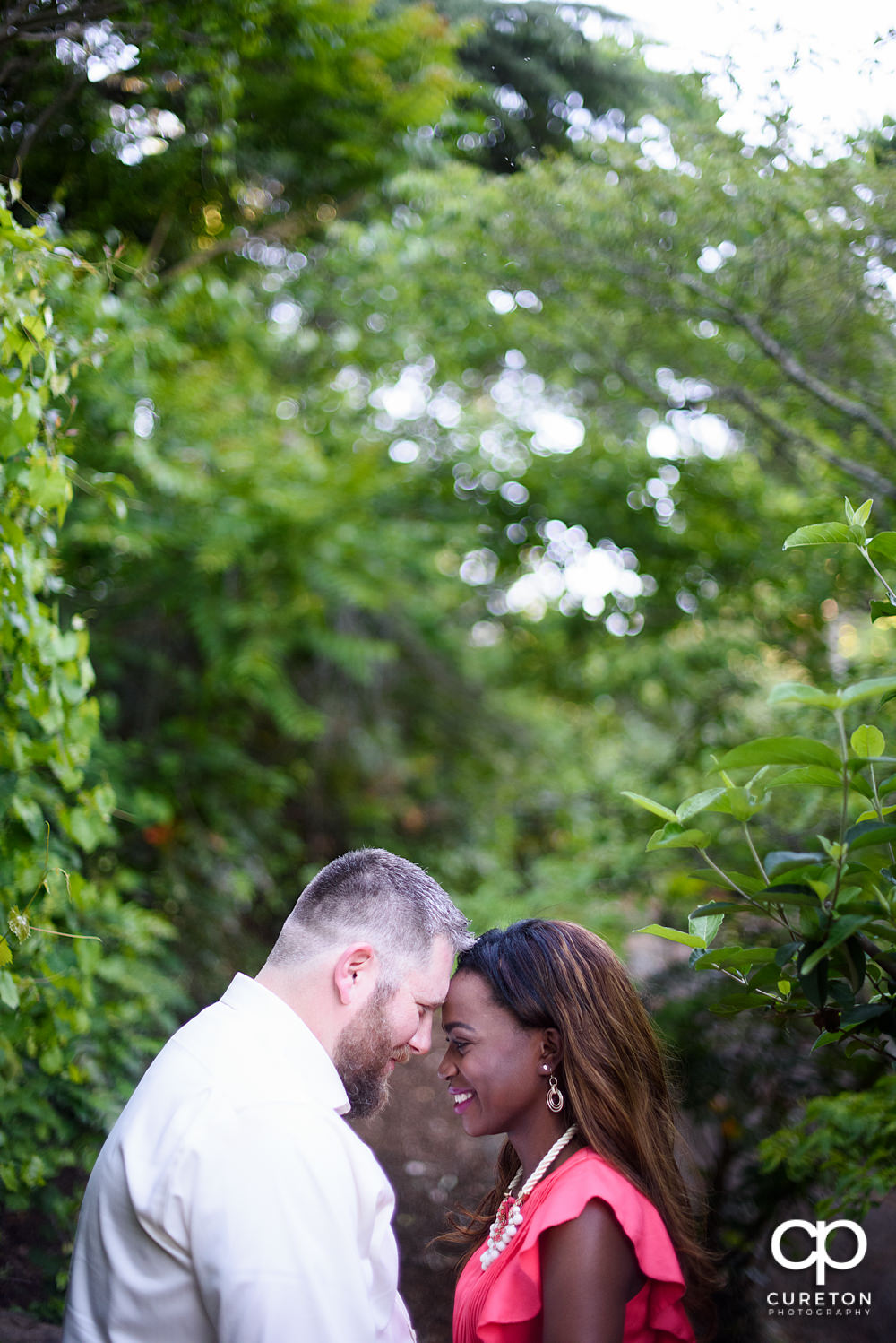 Bride and groom touching foreheads.