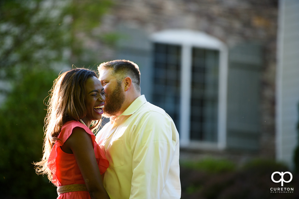 Future groom making his bride laugh during their downtown Greenville park engagement session.