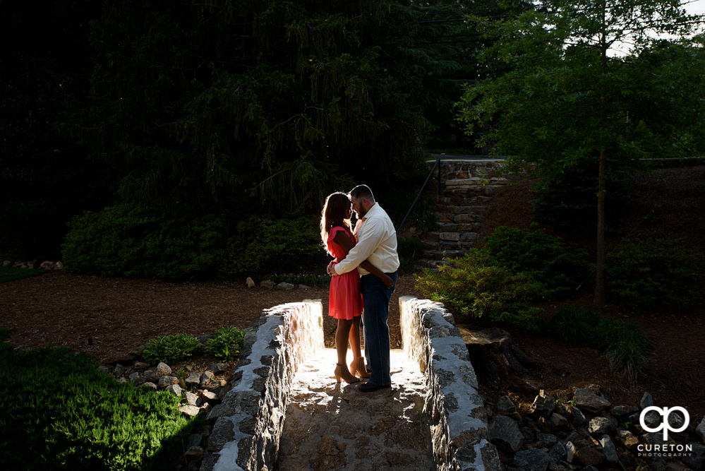Engaged couple on the bridge at the Rock Quarry Garden.
