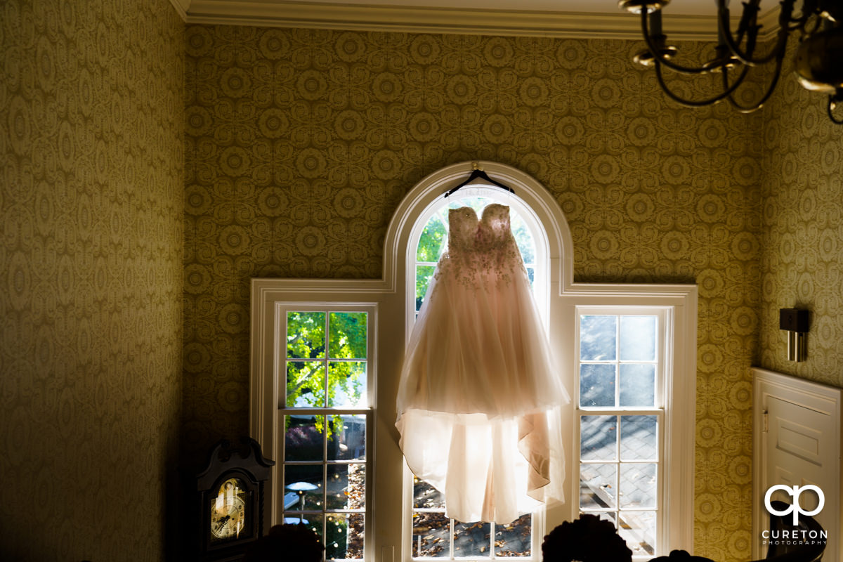 Bride's dress hanging in a window at the Duncan Estate in Spartanburg,SC.