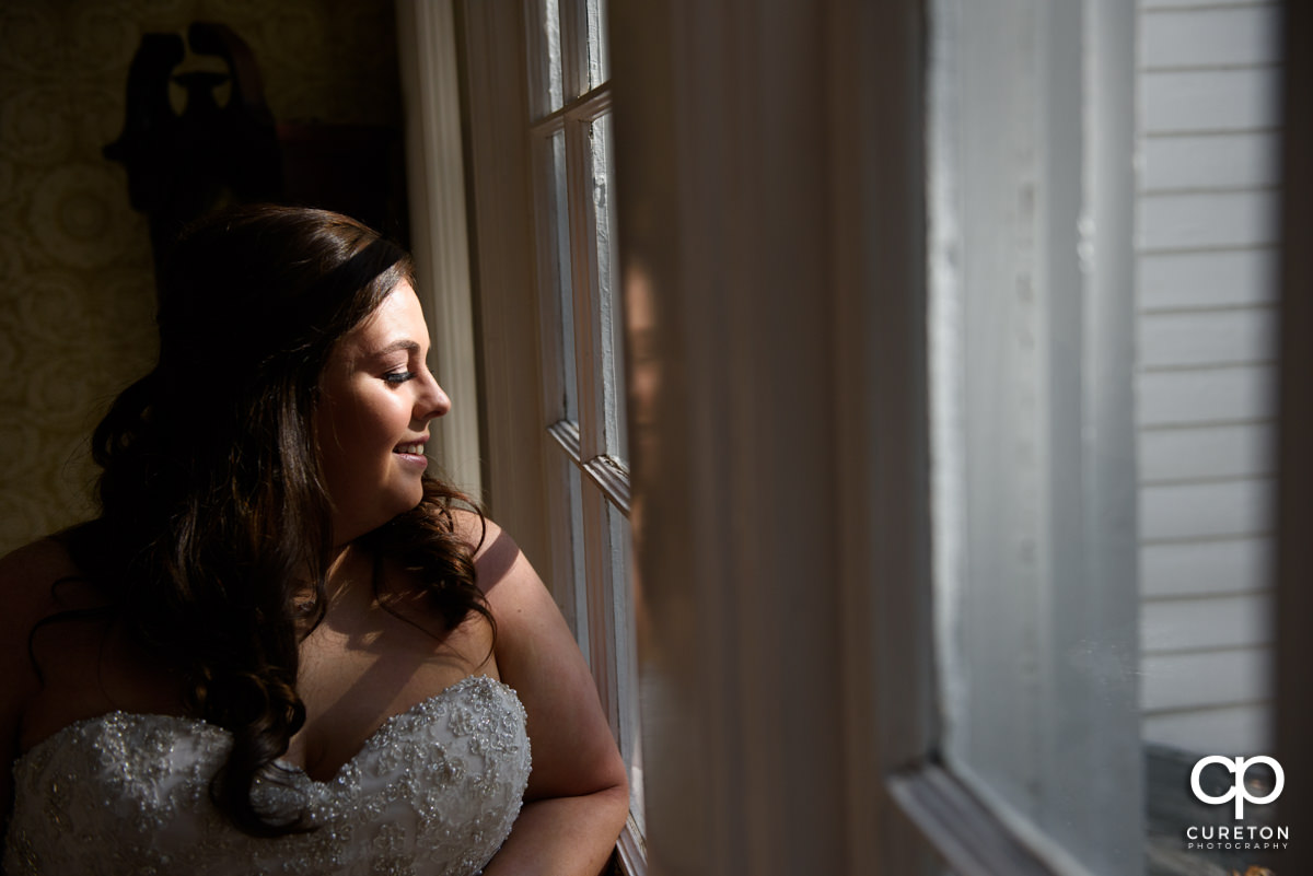 Bride smiling looking out the window.