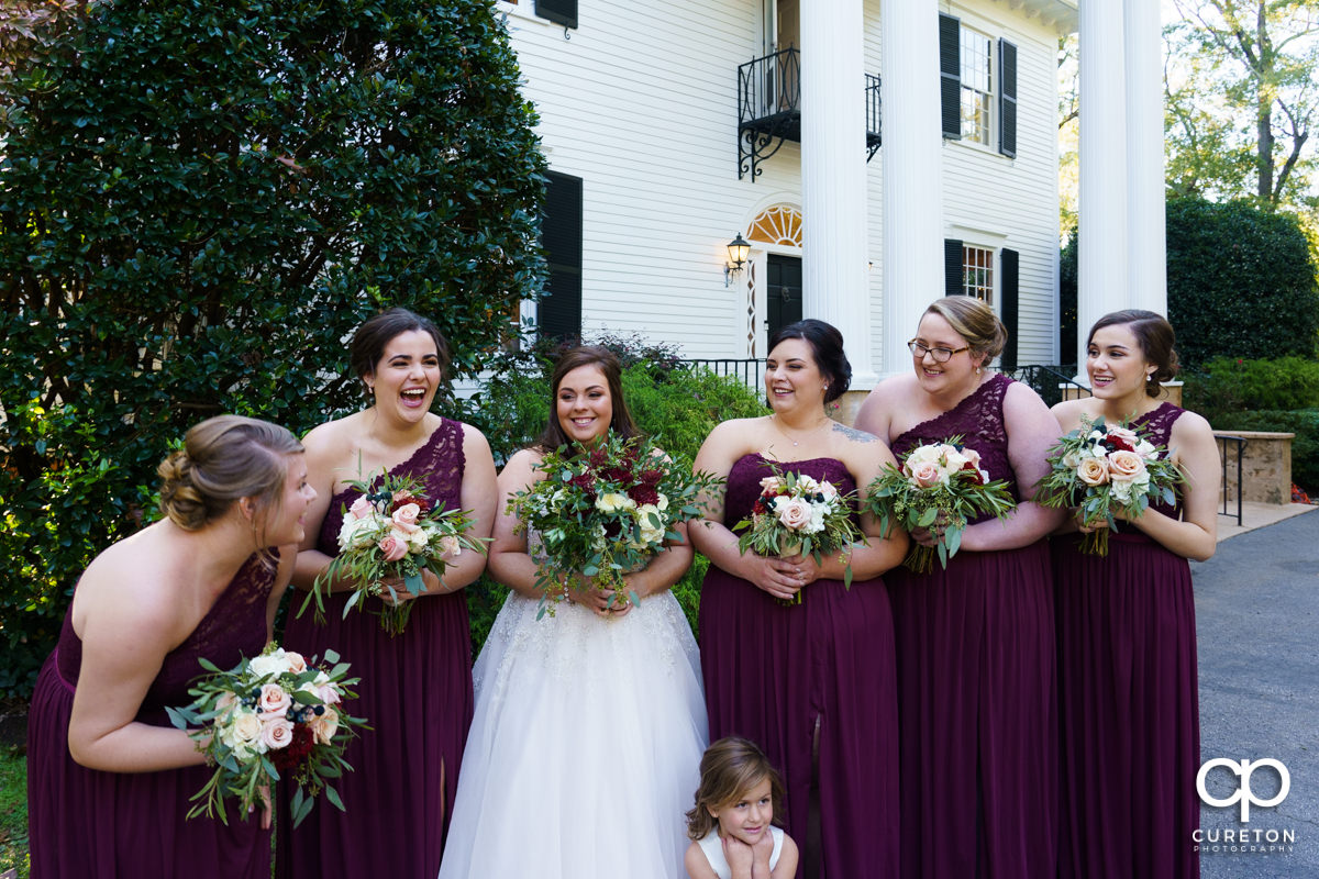 Bride and the bridesmaids laughing while standing in front of the house before the Duncan Estate wedding.
