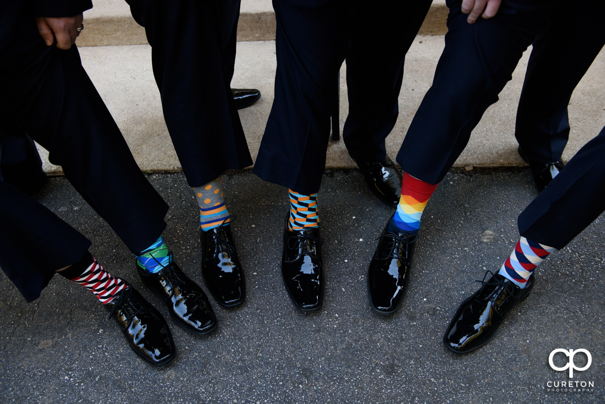 Groom and groomsmen showing off their funky socks.
