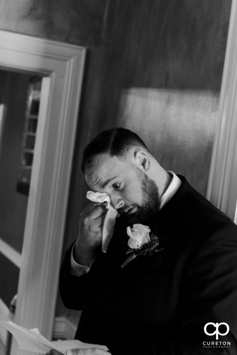 Groom tearing up while praying with his bride before the wedding.