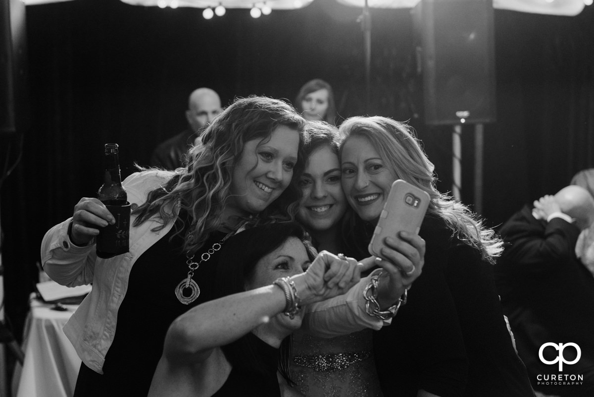 Bride taking a selfie with wedding guests.