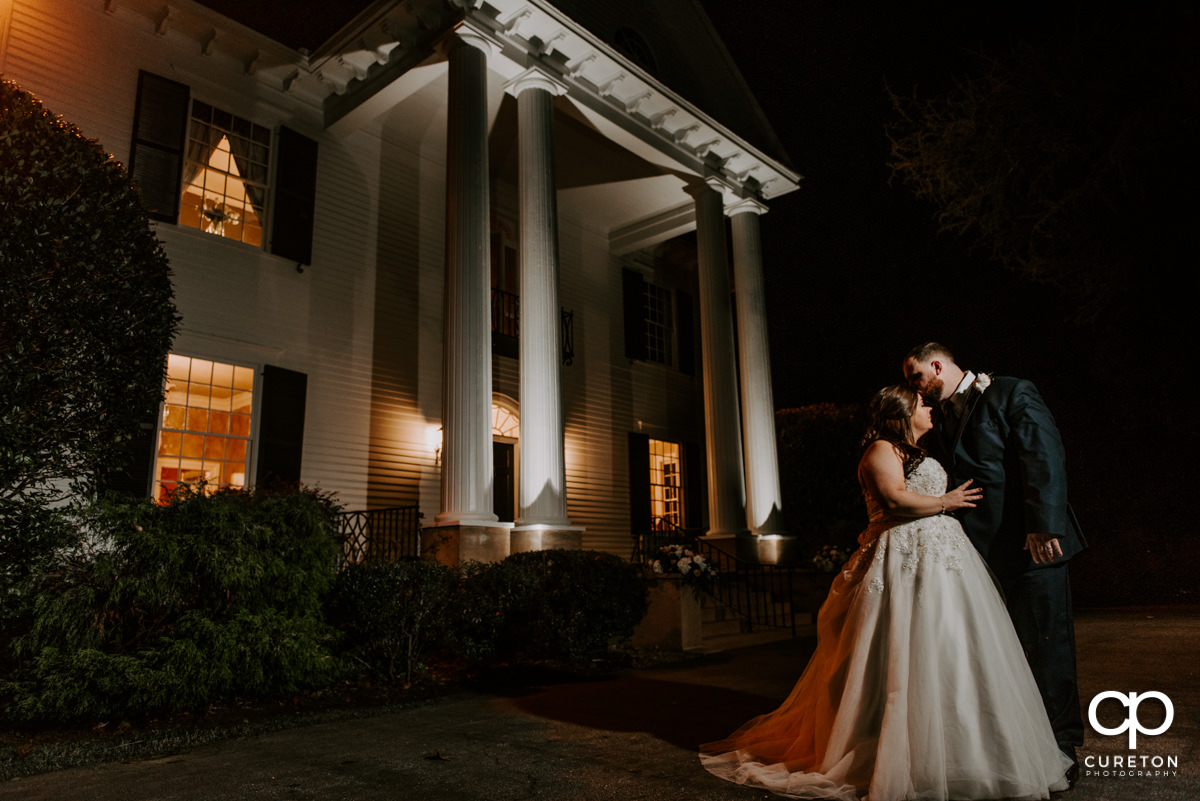 Bride and groom in front of the Duncan Estate house at night
