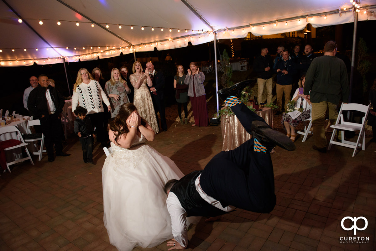 Groom jumping in the air to take off the garter.