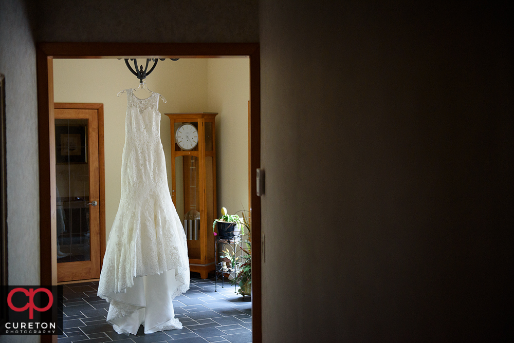 Bride's dress hanging from the chandelier.
