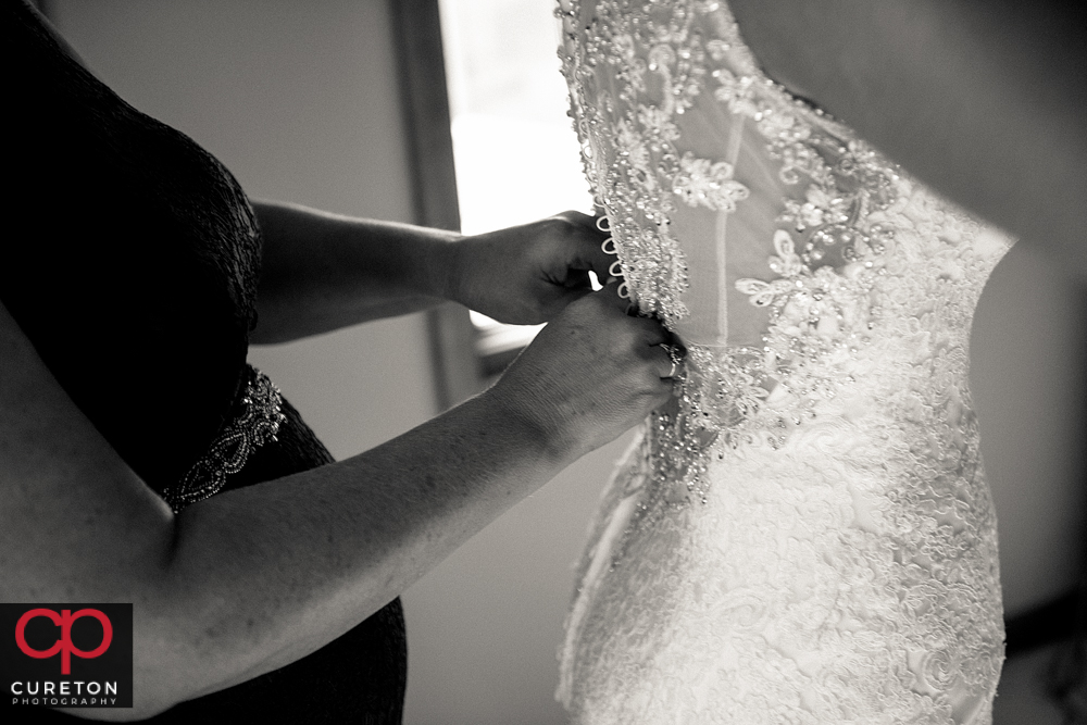 Bride's mom helping her into the dress.