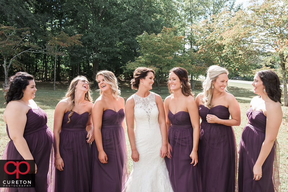 Bride and bridesmaids laughing.