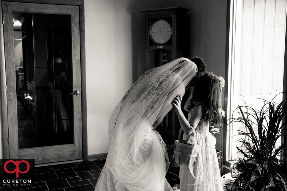 Bride and the flower girl talk before the wedding.