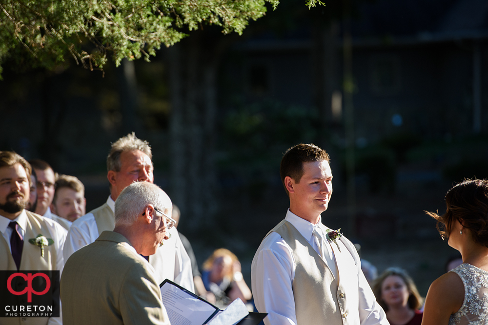 Groom smiling during the ceremony.