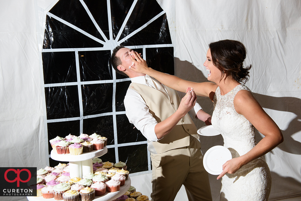 Bride smashing cake on to the groom's face.