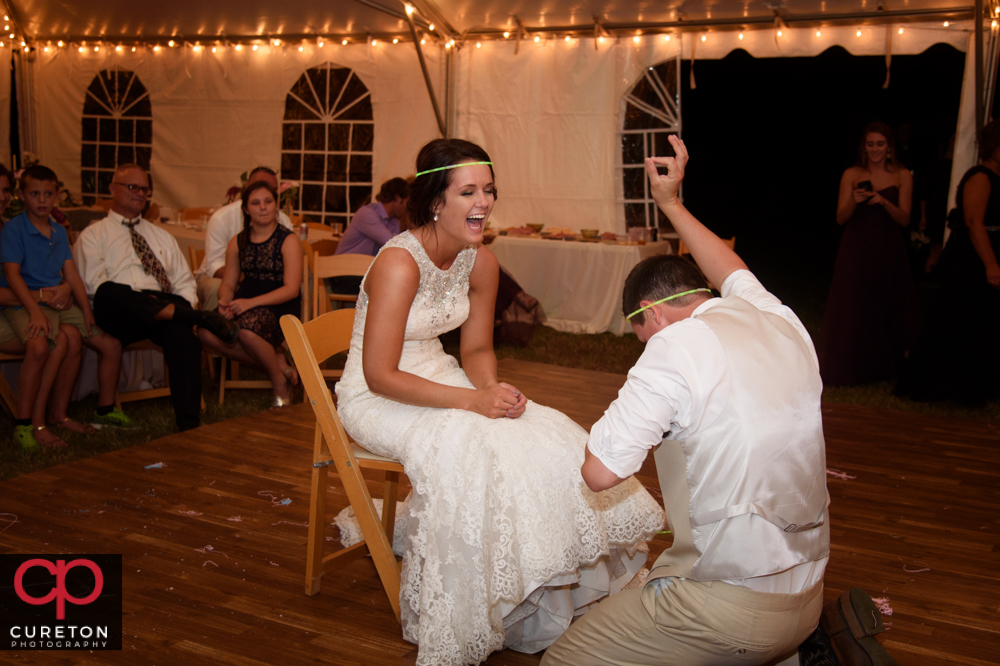 Groom taking the garter off.