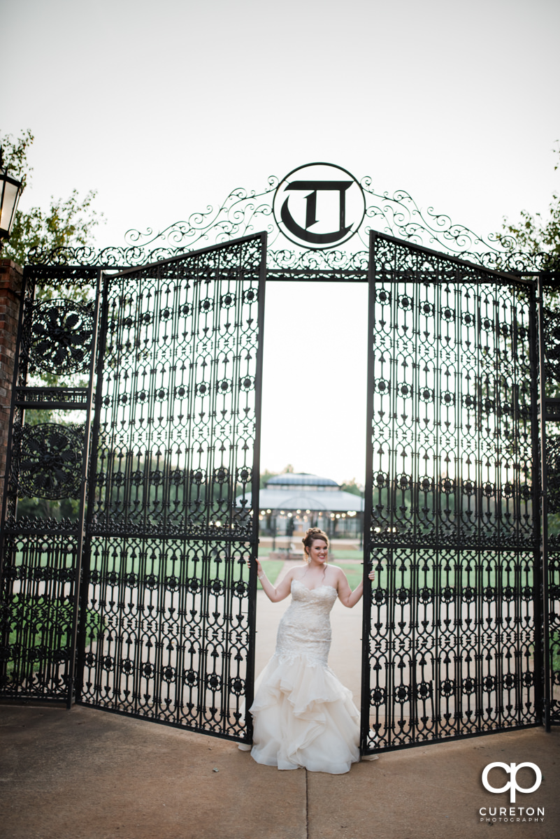 Bride in front of tall iron gates.