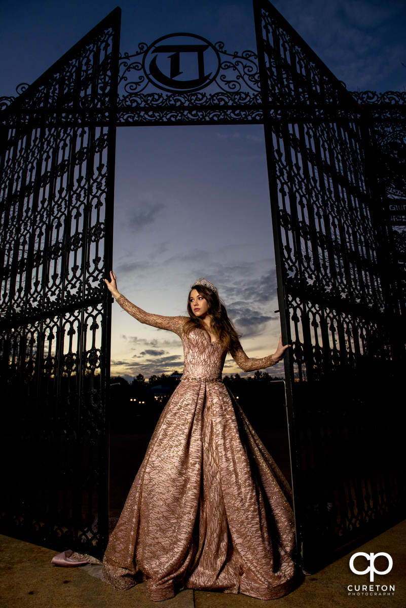 Bride at sunset holding onto an iron gate after her wedding at Edinburgh West in Greenville,SC.