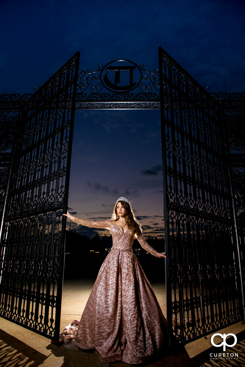 Bride backlit at sunset in front of the gates at the Edinburgh West wedding venue in Greenville,SC.