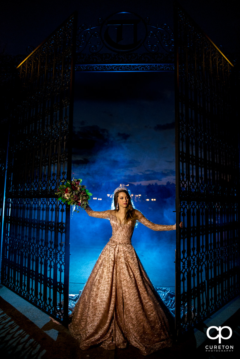 Bride at the gates at the Edinburgh West wedding venue with blue smoke behind her.