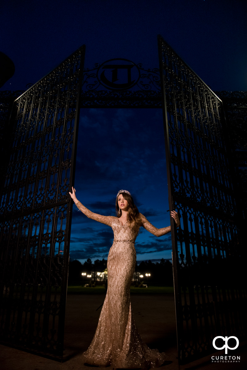 Bride at the gates at the Edinburgh West wedding venue looking into the sunset.