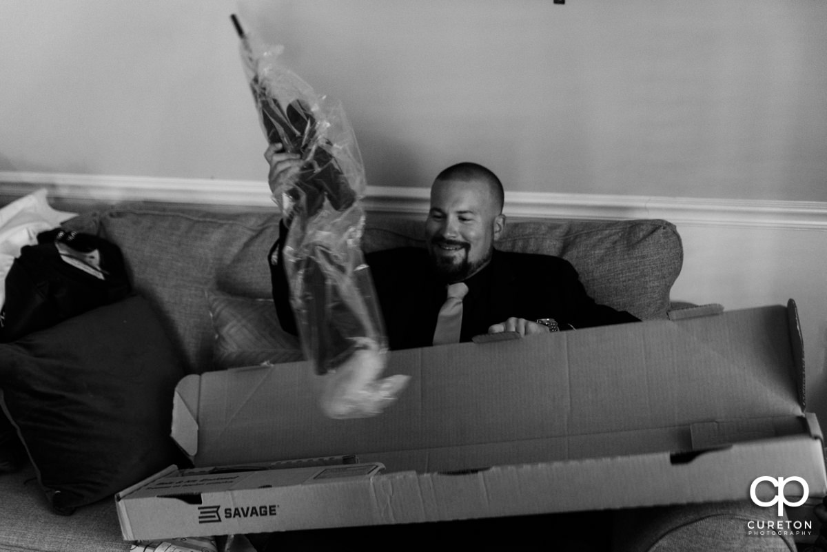 Groom opening up his gift from his bride.