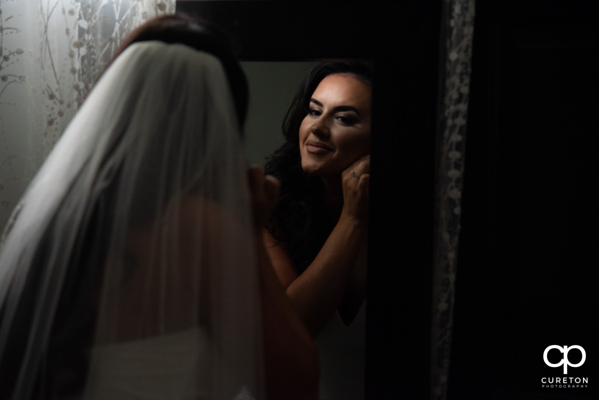 Bride putting her earring in.