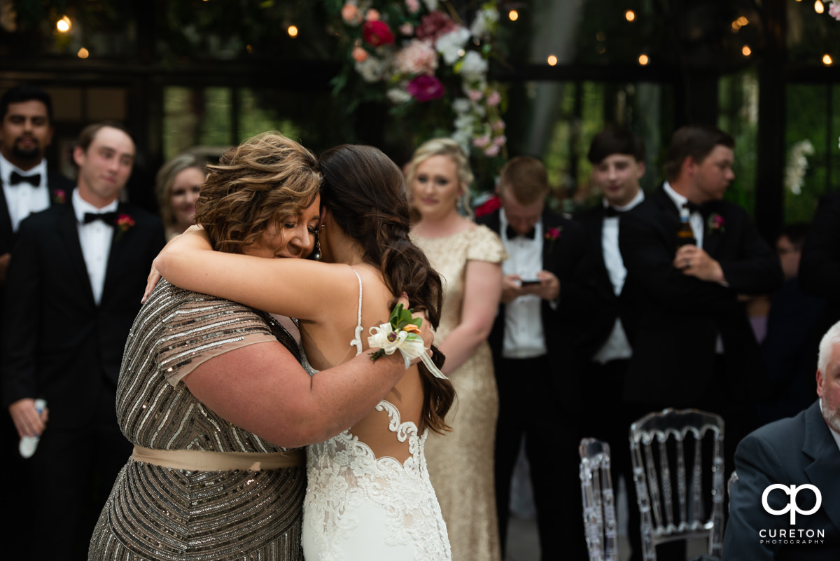 Bride hugging her mom.