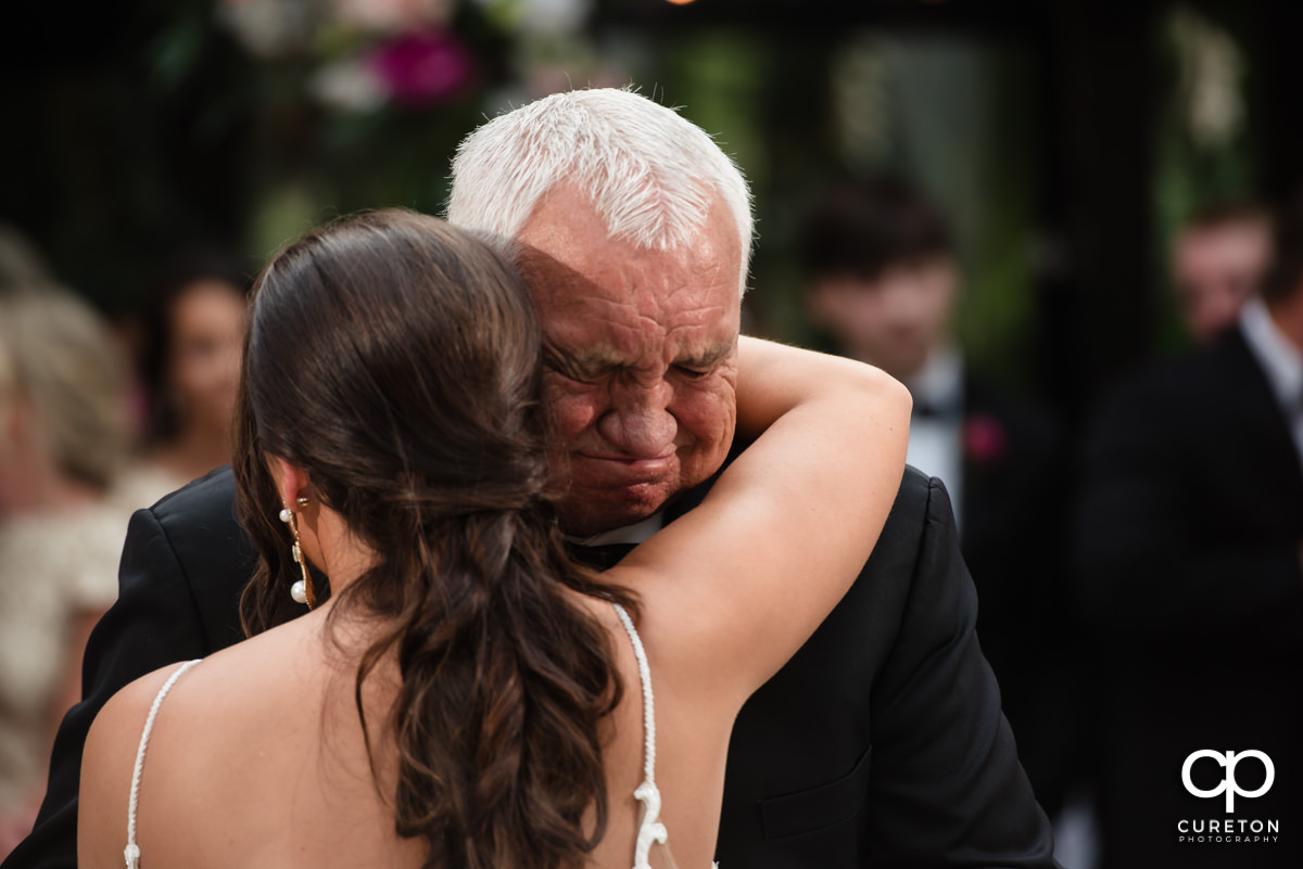 Bride's grandfather crying while dancing with her.