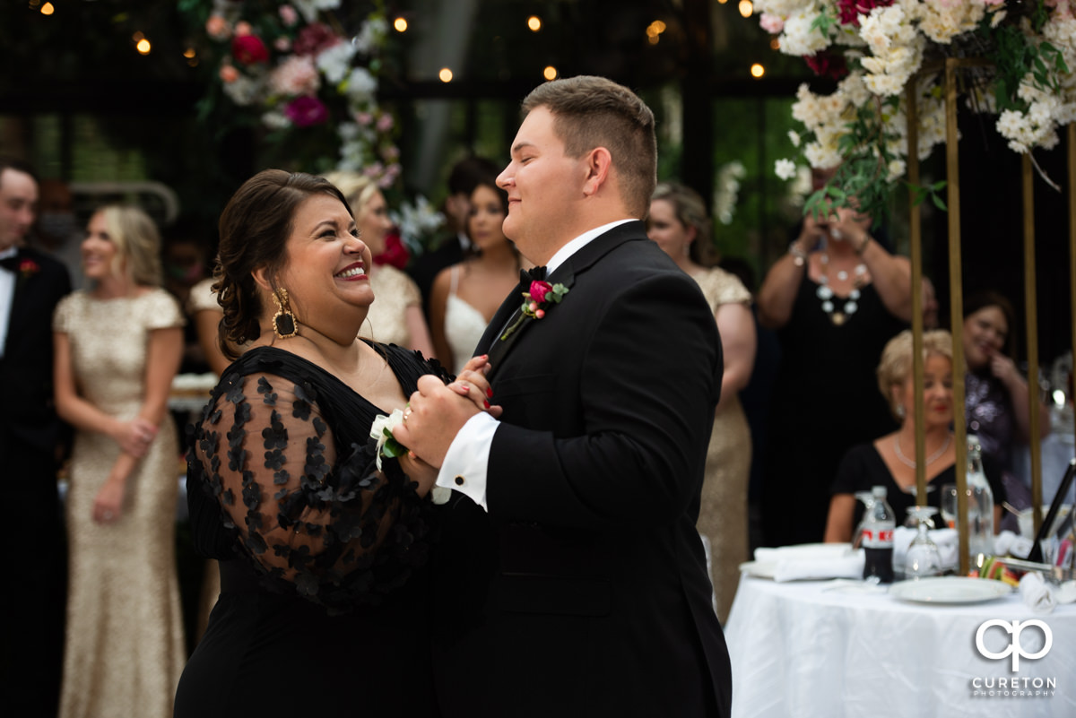 Groom's mother dancing with her son.