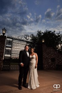 Bride and groom in front of iron gates.