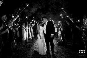 Bride and groom kissing under sparklers.