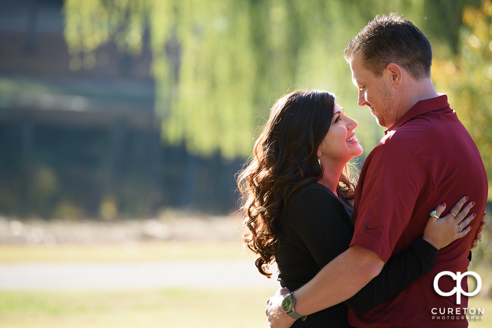 Future bride smiling at her future groom in their engagement session at Furman University.