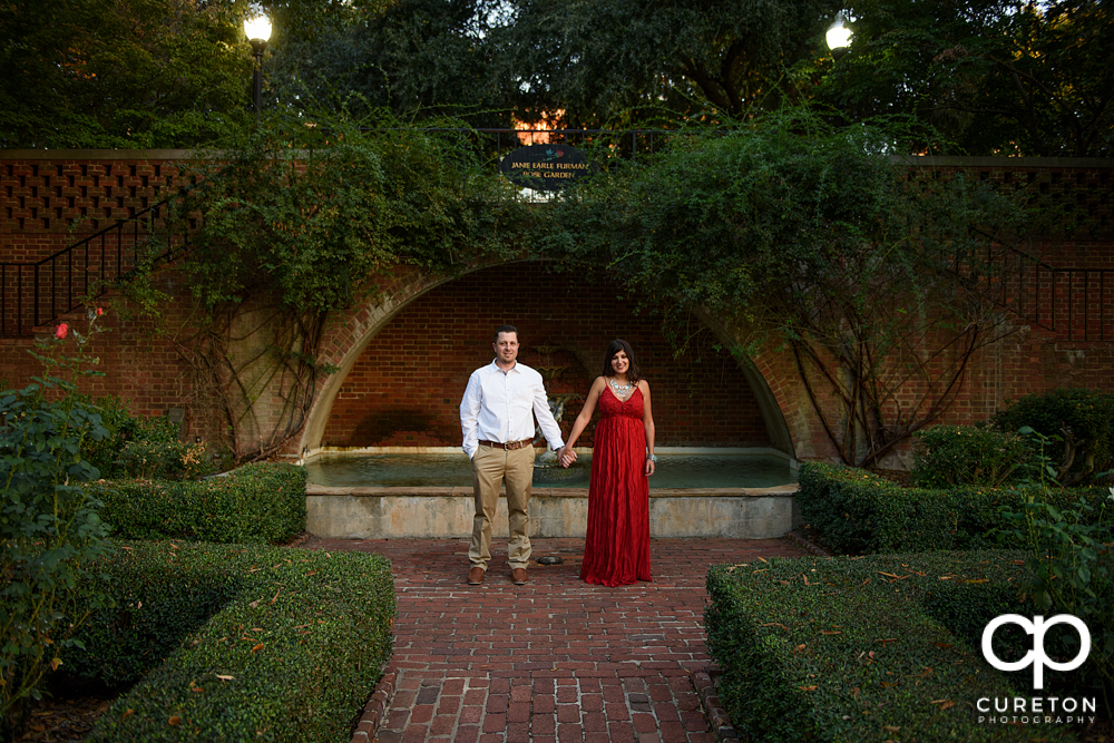Bride and groom holding hands in the Rose Garden at Furman university.